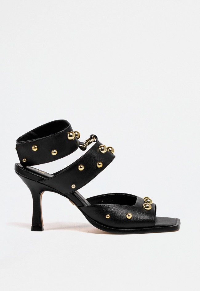 Sandalia de piel negra con tacón fino, tachas doradas y cierre de velcro – elegancia con actitud | CARRANO 78006