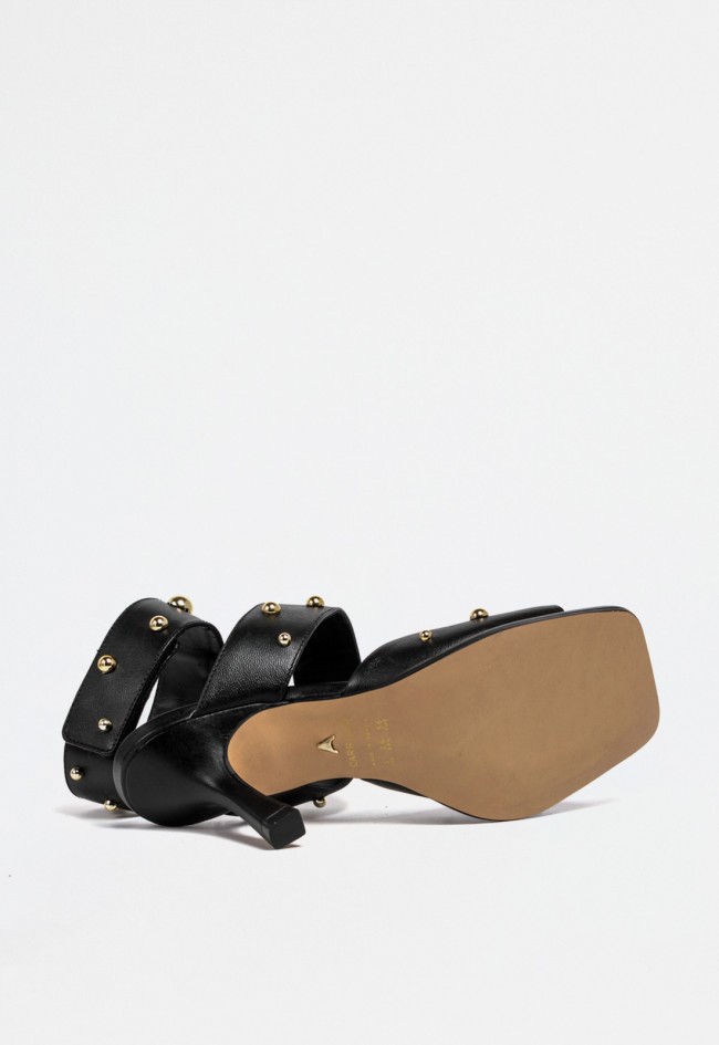 Sandalia de piel negra con tacón fino, tachas doradas y cierre de velcro – elegancia con actitud | CARRANO 78006