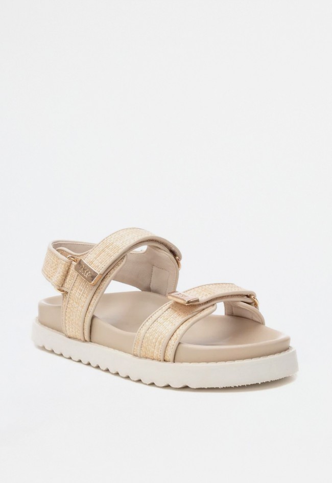 Sandalia plana de mujer en rafia con doble pala, cierre adhesivo y detalles metálicos | XTI 144128