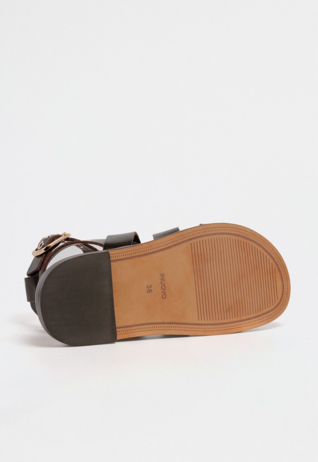 Sandalia plana de mujer estilo romana en piel marrón con tachuelas doradas y cierre al tobillo con hebilla VAS d51013