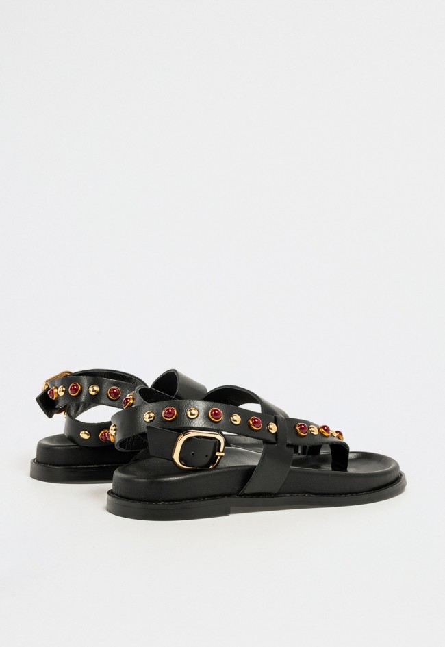 Sandalia plana de mujer en piel negra con tachuelas doradas y piedras burdeos de estilo atrevido VAS d51004