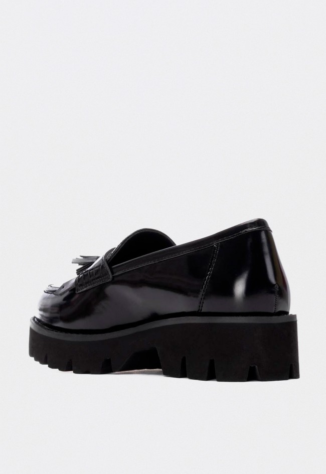 Mocasín negro de mujer XTI con plataforma chunky con borlas y flecos tendencia