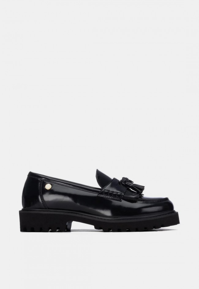 Mocasín de mujer Xti 14630001 en material sintético negro con borlas, un clásico renovado